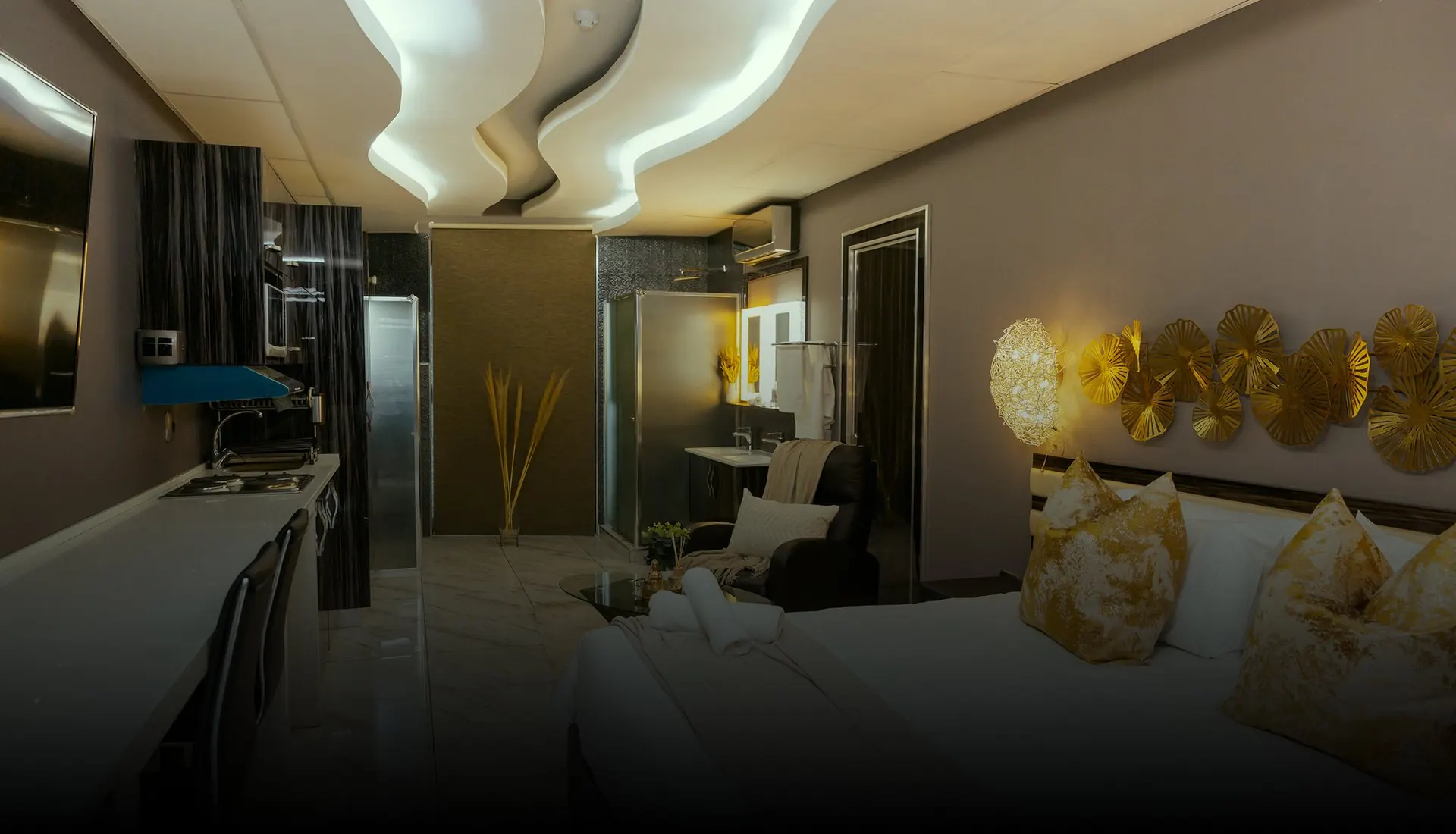 Suite at Monte La Vue with a king bed, gold wall décor and a sculpted ceiling light